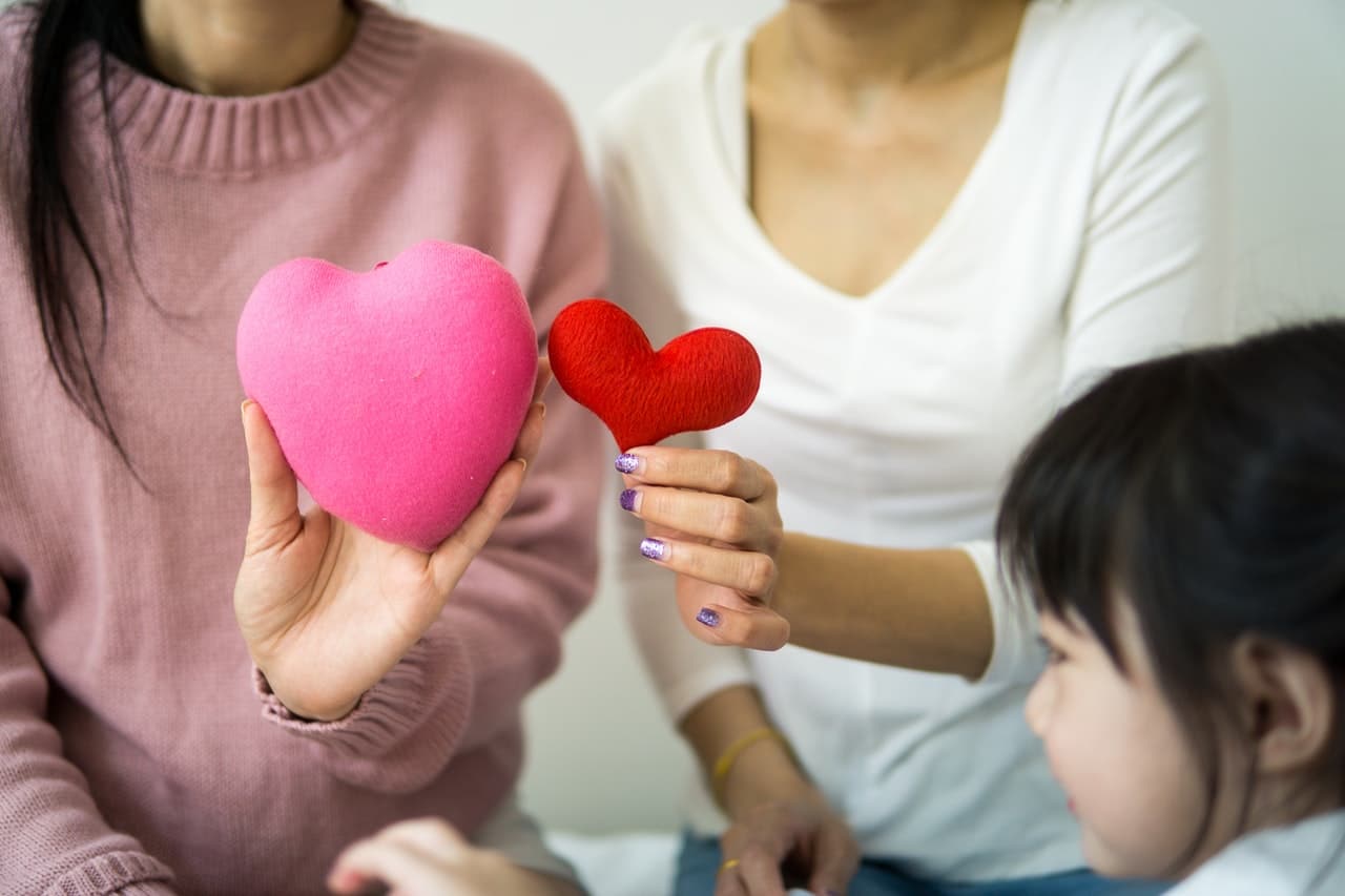 two women holding hearts