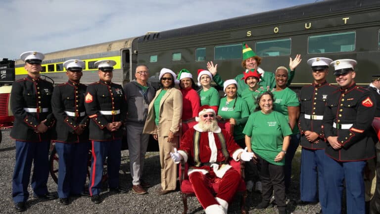 Santa in front of train with volunteers