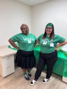 2 staff members at FCHC Belle Glade wearing matching "Lucky" 4 leaf clover shirts.