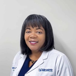 Headshot of Sheryl Timol, Family Nurse Practitioner, smiling in a white FCHC lab coat.
